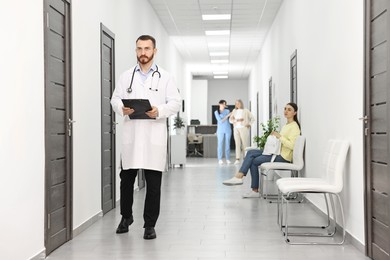 Patients waiting for appointment and doctors in hospital hallway, selective focus