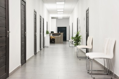 Empty hospital corridor with chairs and doors