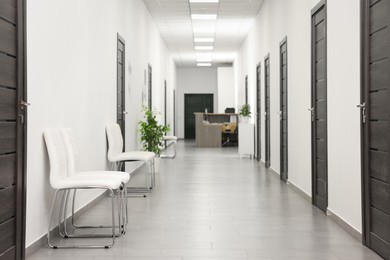 Photo of Empty hospital corridor with chairs and doors