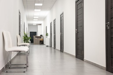 Photo of Empty hospital corridor with chairs and doors