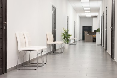 Empty hospital corridor with chairs and doors