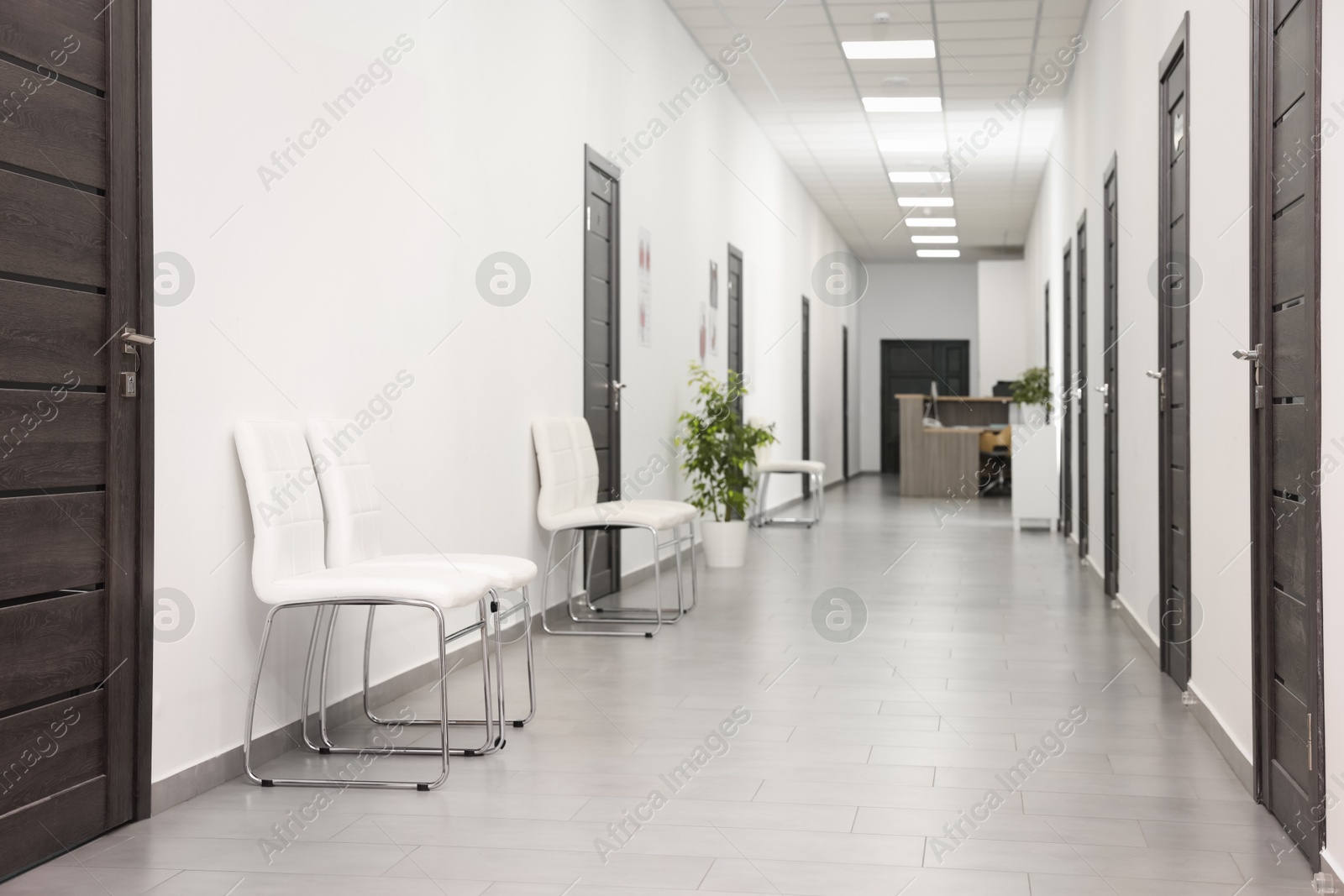 Photo of Empty hospital corridor with chairs and doors