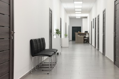 Photo of Empty hospital corridor with chairs and doors