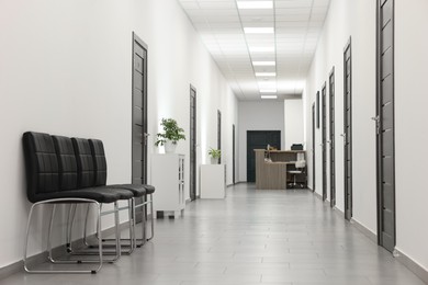 Photo of Empty hospital corridor with chairs and doors