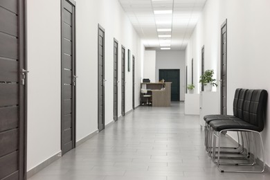 Photo of Empty hospital corridor with chairs and doors