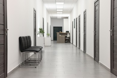 Photo of Empty hospital corridor with chairs and doors