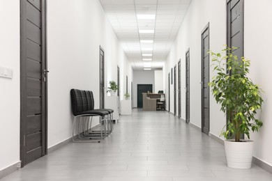 Photo of Empty hospital corridor with chairs and doors