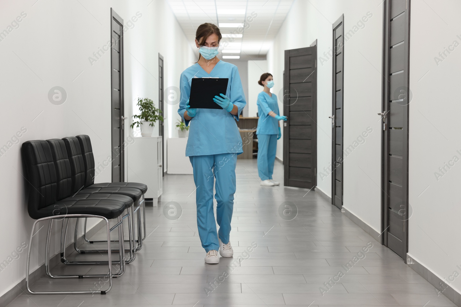 Photo of Nurse working with clipboard in hospital hallway