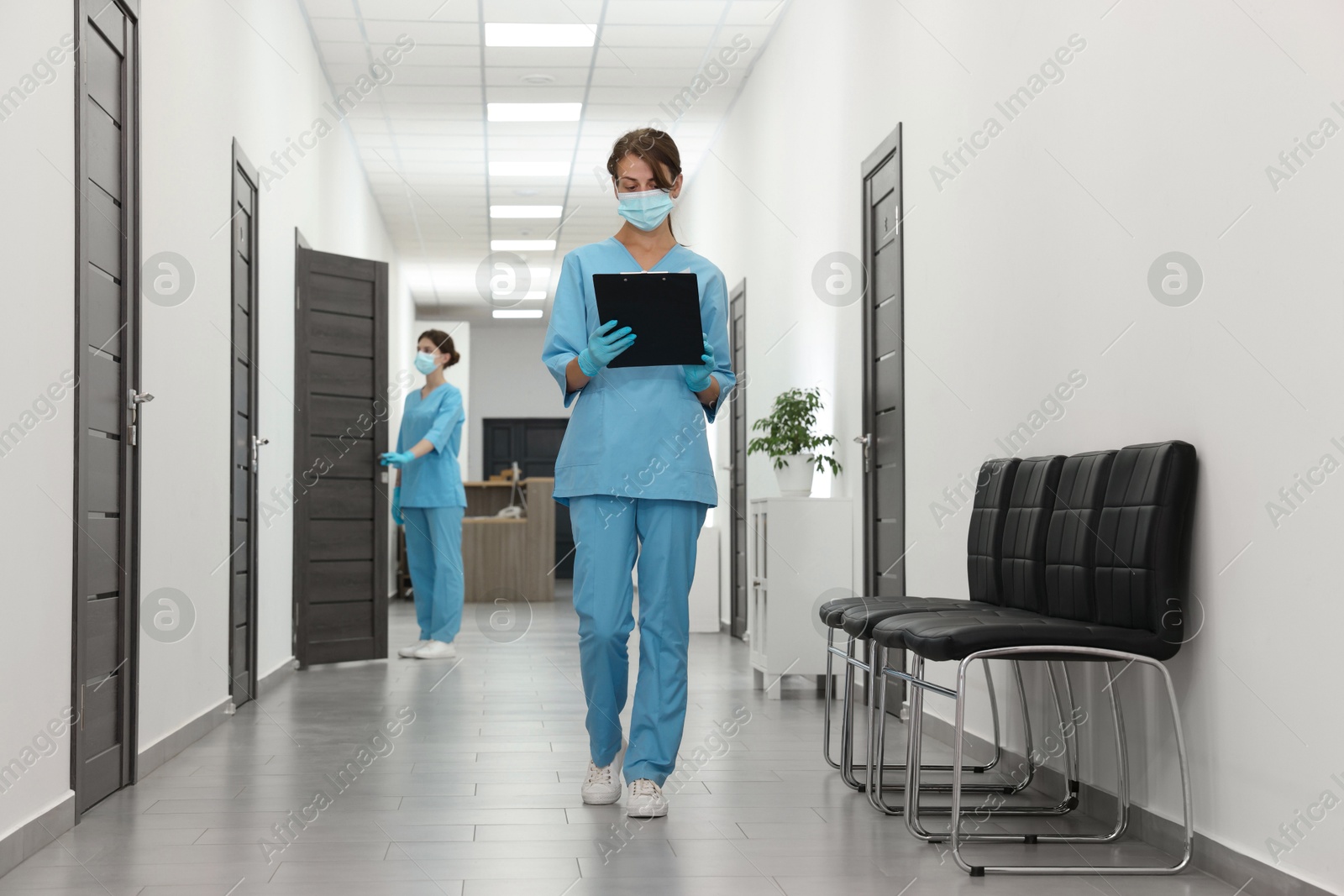 Photo of Nurse working with clipboard in hospital hallway