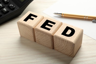 Photo of Wooden cubes with letters Fed (Federal Reserve System) on table