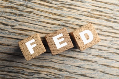 Photo of Cubes with letters Fed (Federal Reserve System) on wooden table, top view