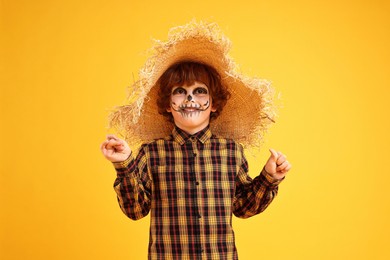 Photo of Funny boy dressed like scarecrow on yellow background. Halloween celebration