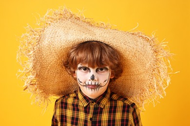 Photo of Funny boy dressed like scarecrow on yellow background. Halloween celebration