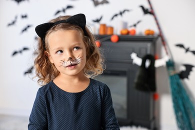 Photo of Funny girl dressed like cat indoors, space for text. Halloween costume