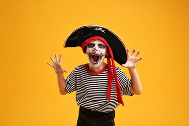 Photo of Funny boy dressed like pirate on yellow background. Halloween costume