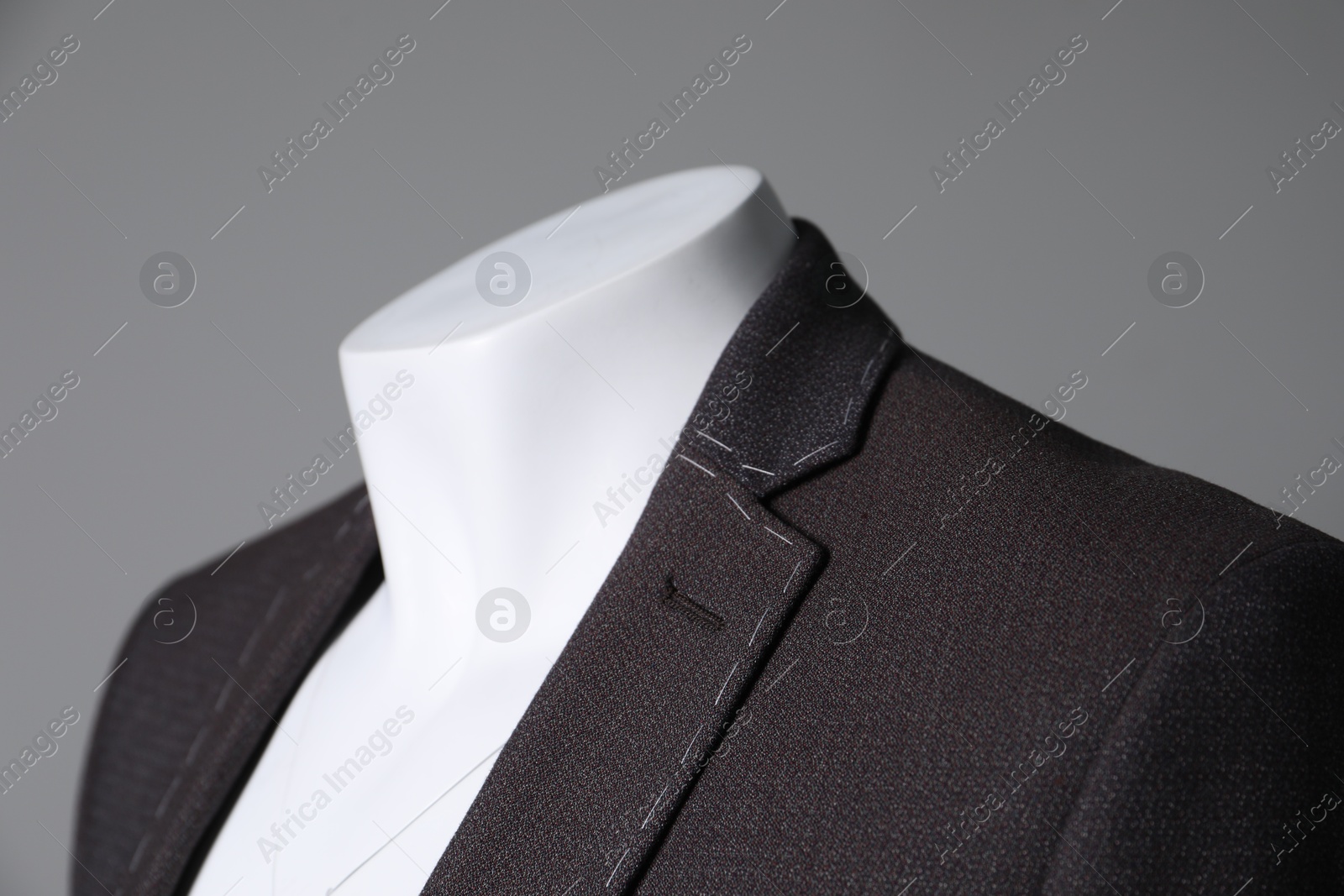 Photo of Semi-ready jacket on mannequin against grey background, closeup