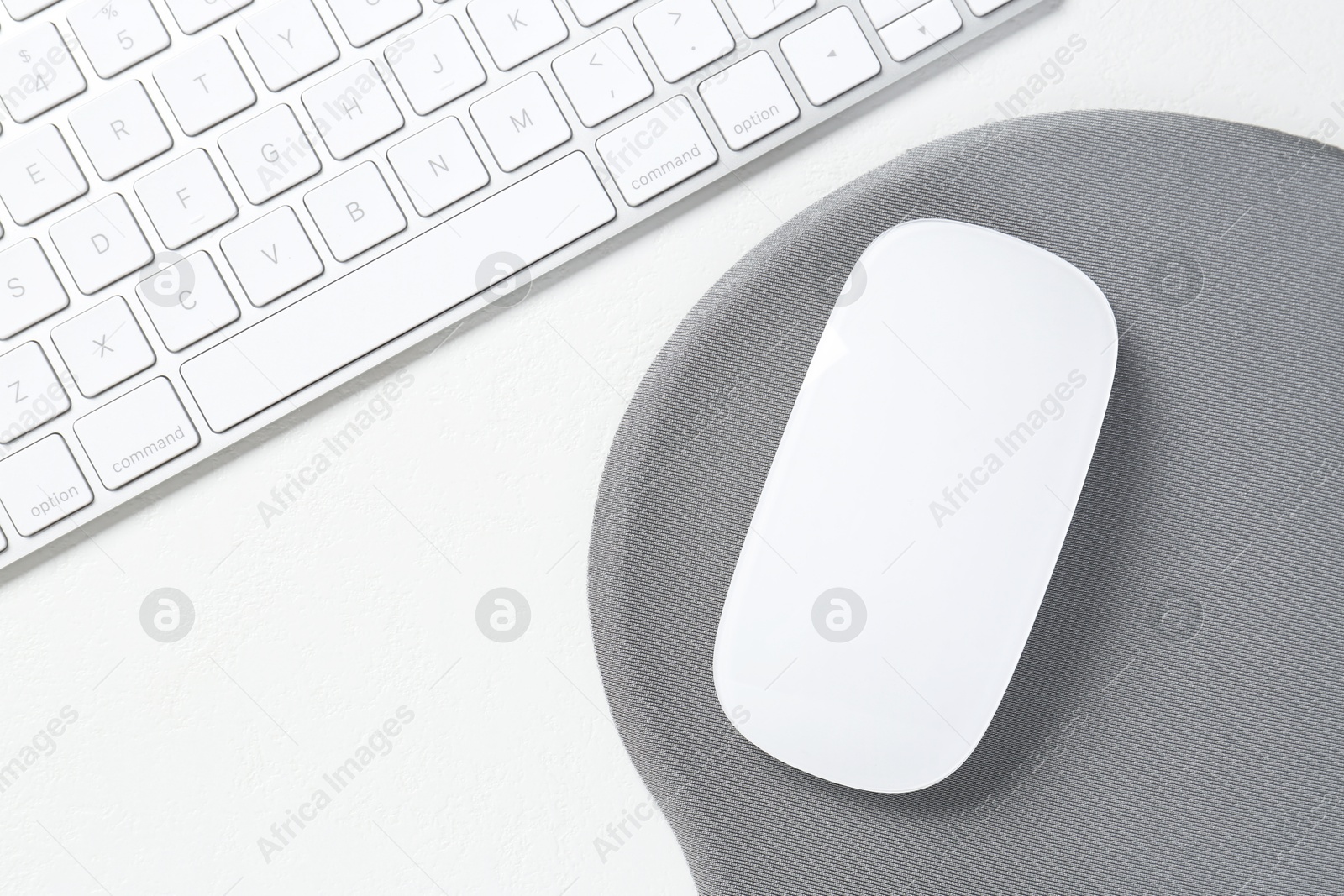 Photo of Keyboard, mouse and mousepad on white table, top view