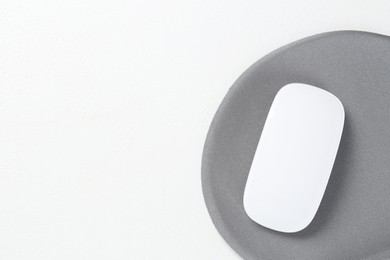 Photo of Mouse and mousepad on white table, top view. Space for text