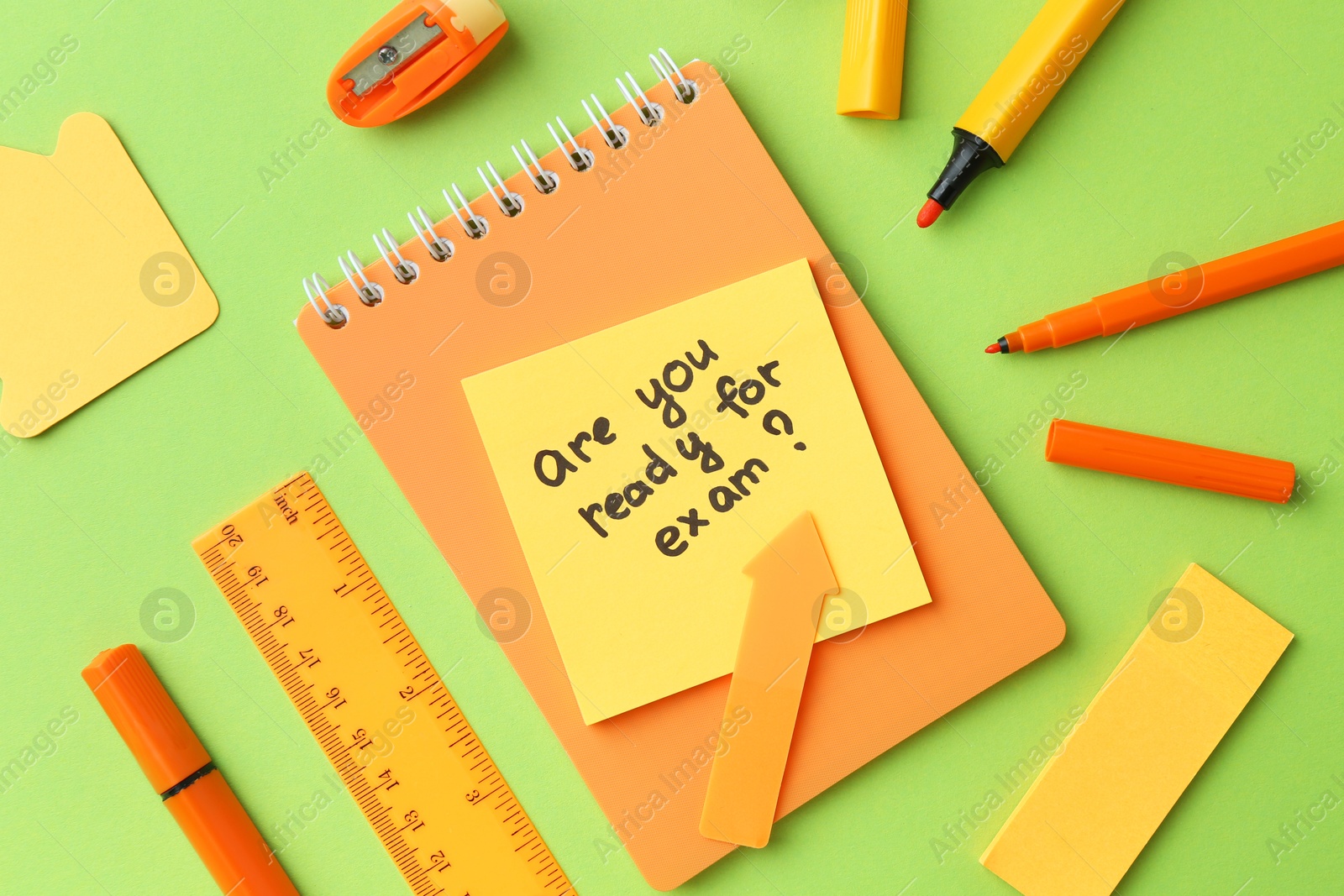 Photo of Paper note with question Are You Ready For Exam and stationery on green background, flat lay