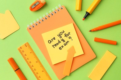 Paper note with question Are You Ready For Exam and stationery on green background, flat lay