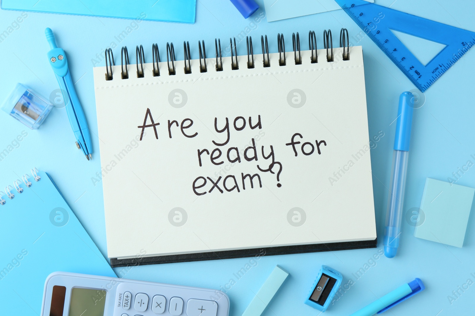 Photo of Notepad with question Are You Ready For Exam and stationery on light blue background, flat lay