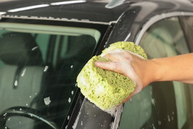 Man washing auto with sponge at car wash, closeup