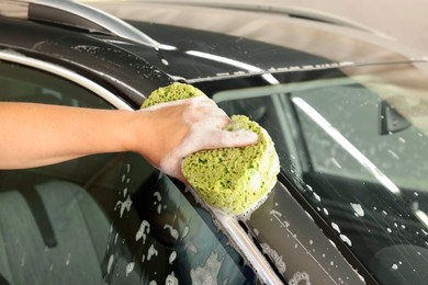 Man washing auto with sponge at car wash, closeup