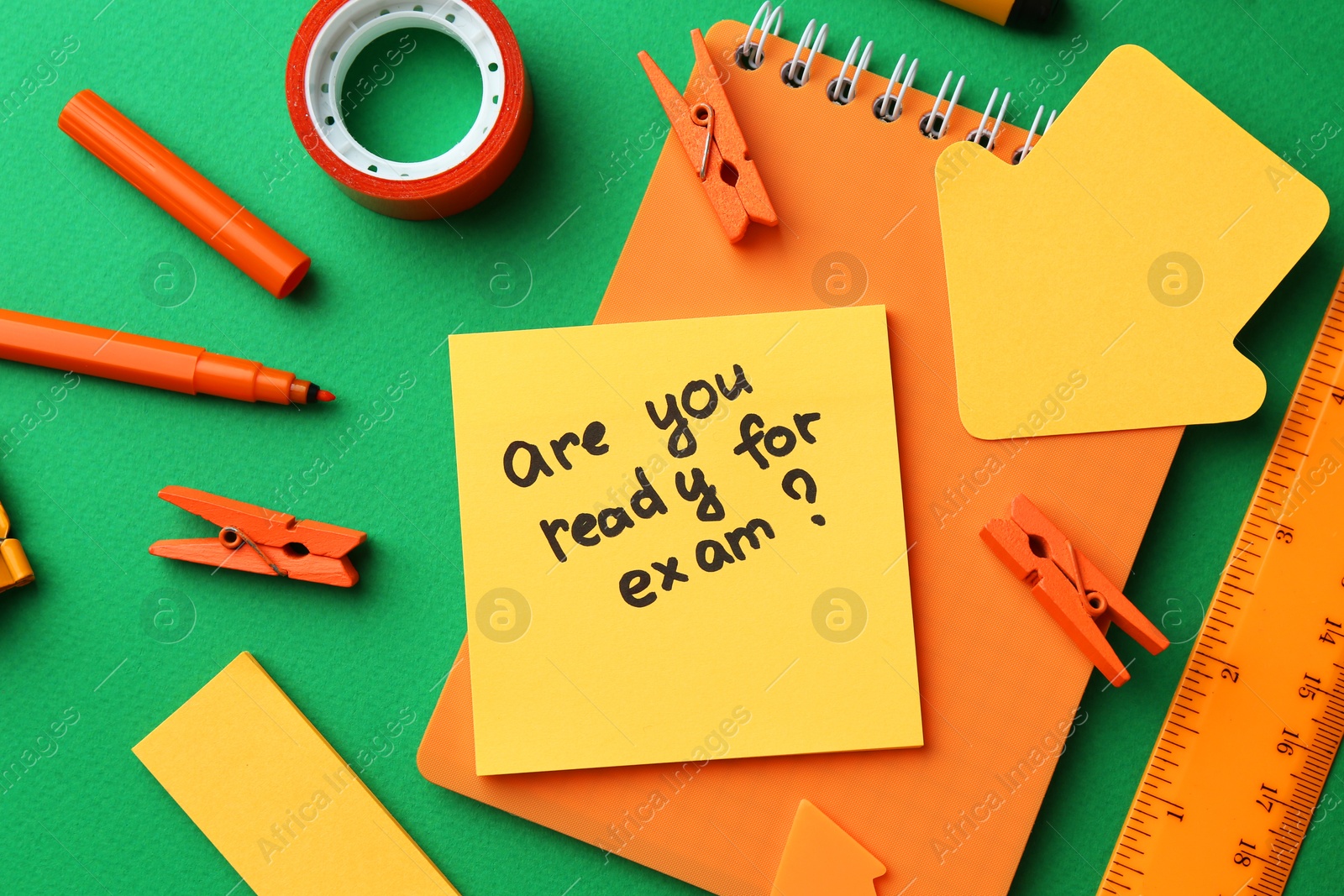 Photo of Paper note with question Are You Ready For Exam and stationery on green background, flat lay