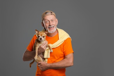 Photo of Portrait of happy senior man with cute Chihuahua dog on grey background. Space for text