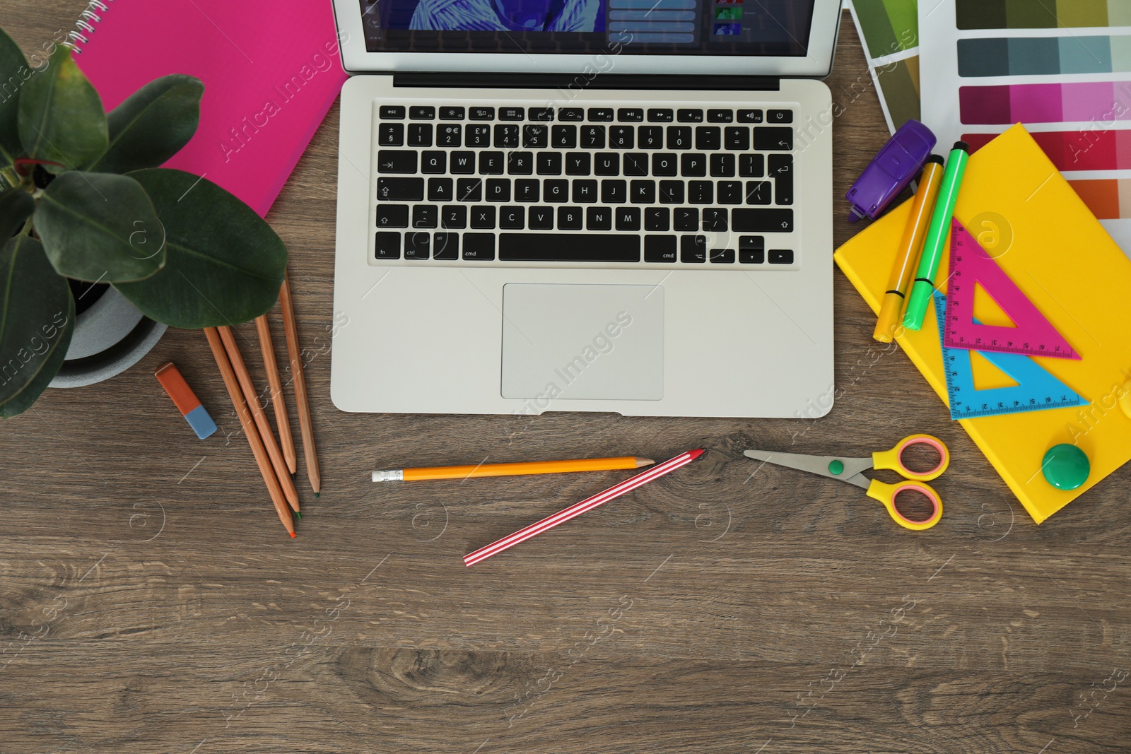 Photo of Fashion designer`s workplace with laptop, color palette and different stationery on wooden table, flat lay