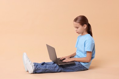 Girl with correct posture and laptop sitting on beige background