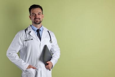 Smiling doctor with stethoscope and laptop on olive background, space for text