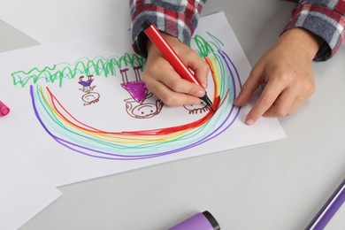 Photo of Boy drawing his family at light table, closeup