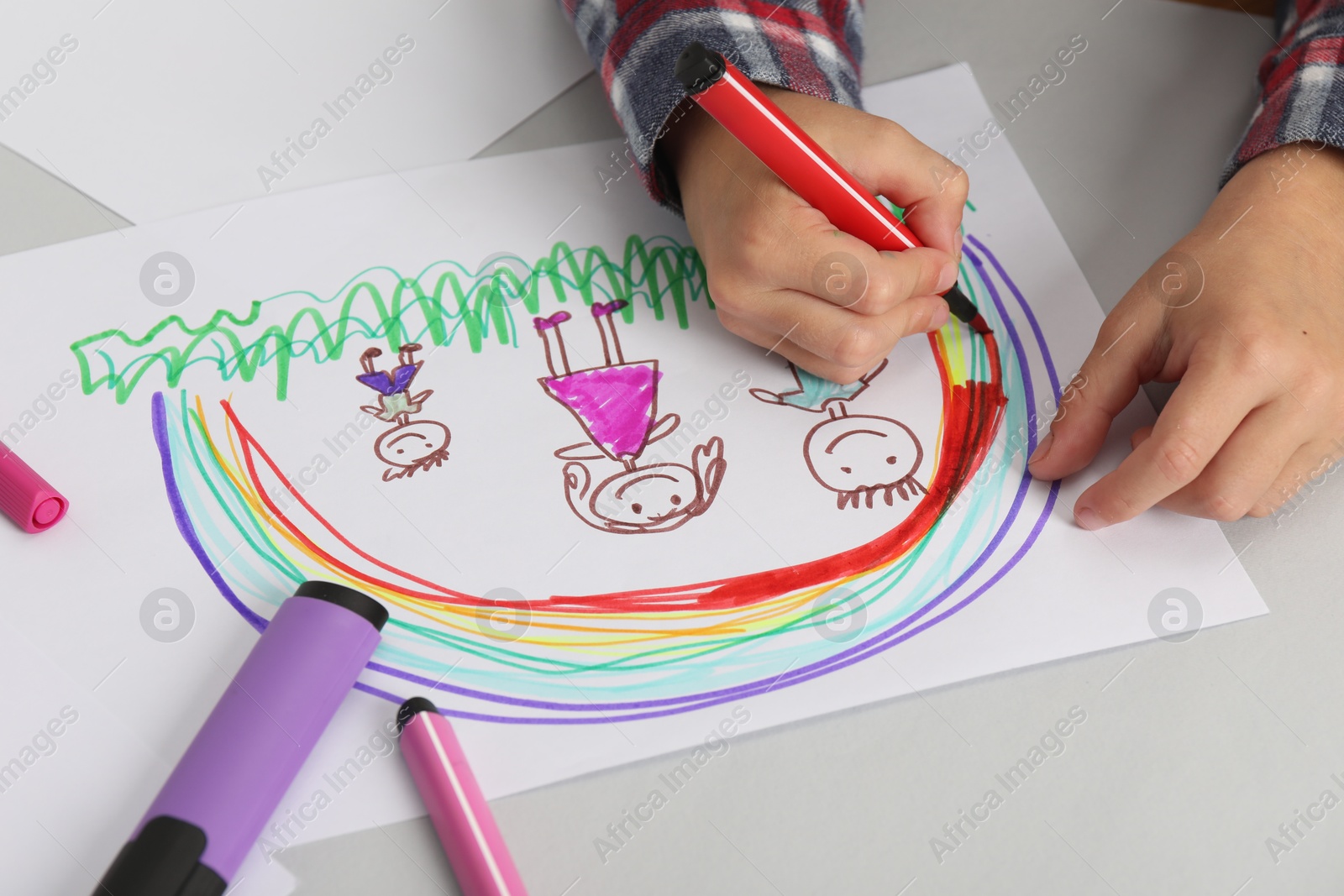 Photo of Boy drawing his family at light table, closeup