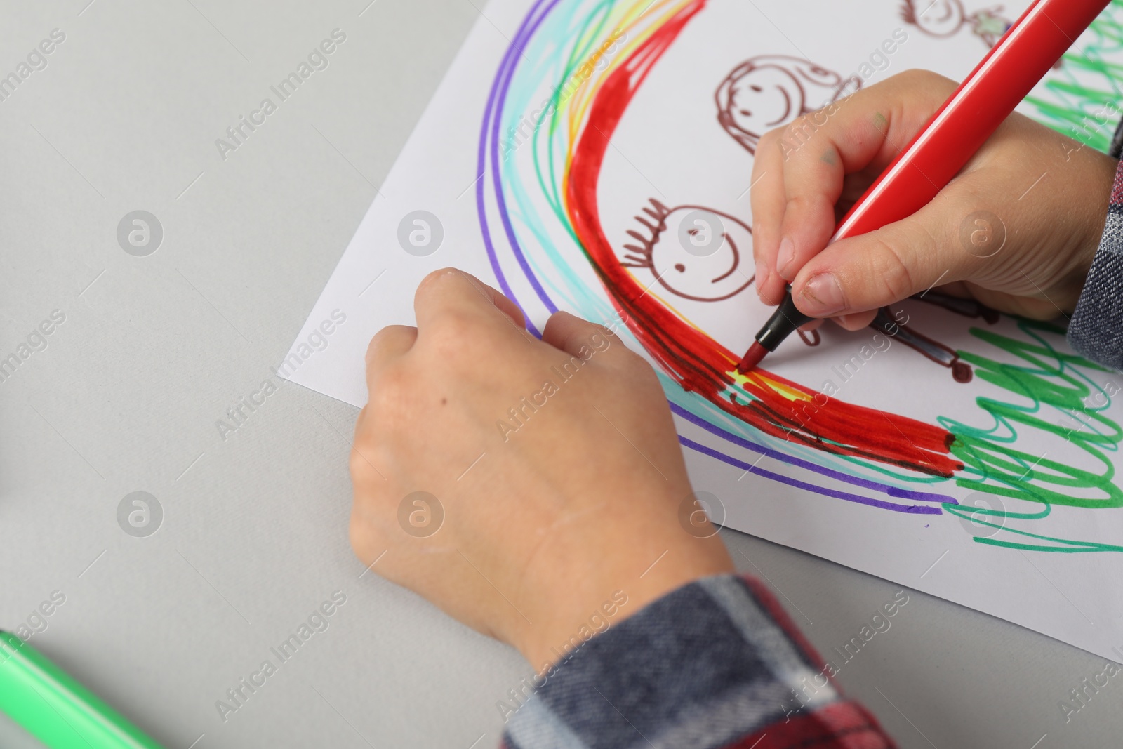 Photo of Boy drawing his family at light table, closeup