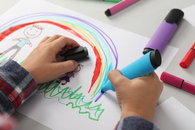 Photo of Boy drawing his family at light table, closeup