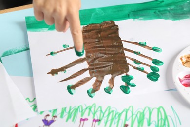 Boy drawing picture with paint at table, closeup