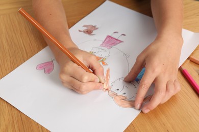 Boy drawing his family at wooden table, closeup