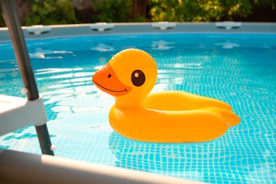 Photo of Inflatable duck shaped ring on water in above ground swimming pool outdoors