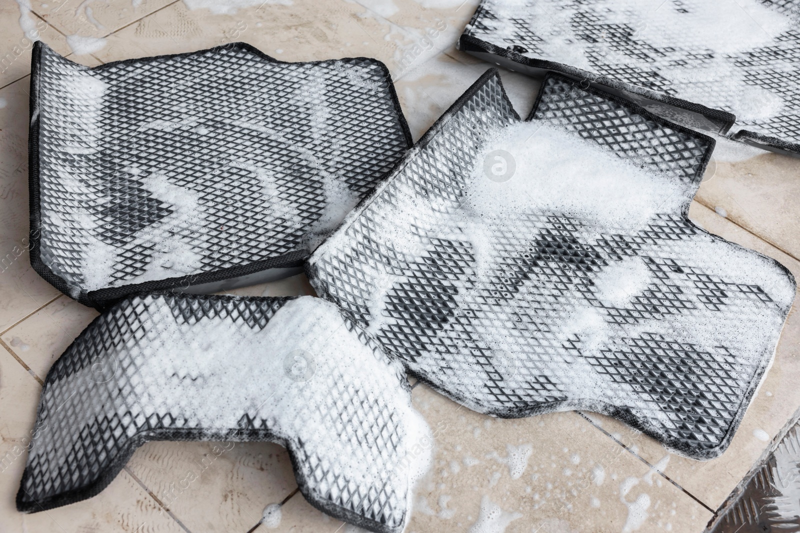 Photo of Car floor mats covered with foam indoors