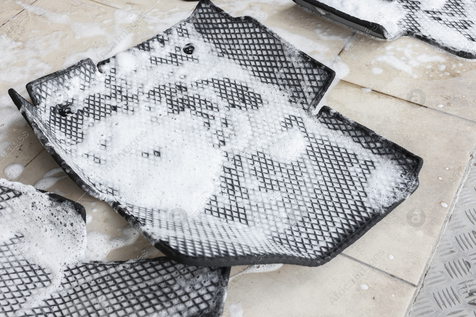 Photo of Car floor mats covered with foam indoors