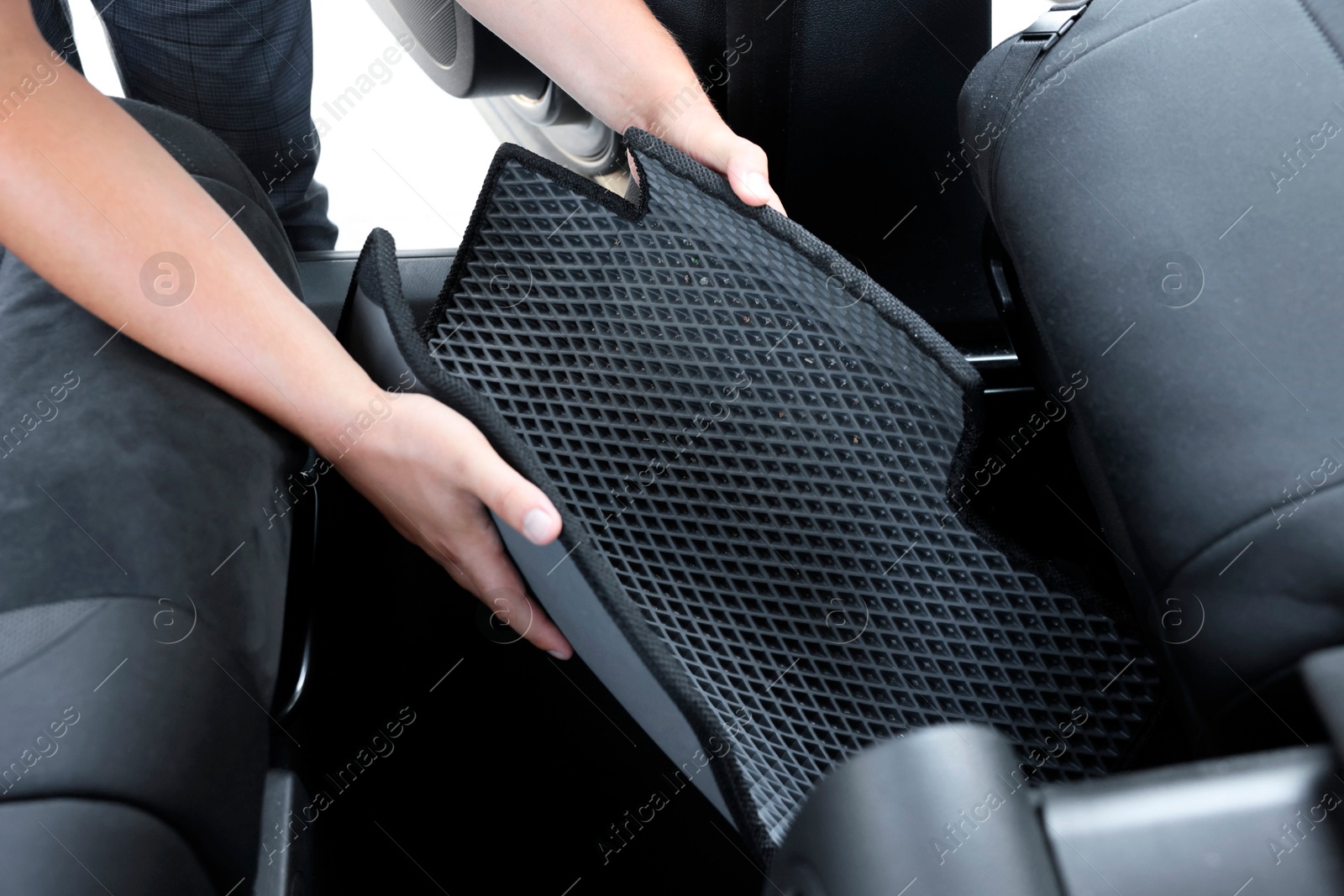 Photo of Man taking grey rubber car mat from auto, closeup