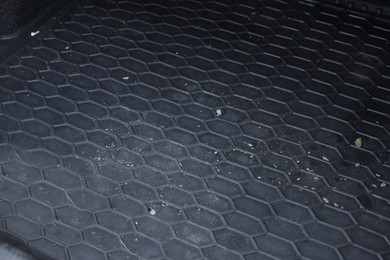 Photo of Black rubber car boot liner mat in auto, closeup