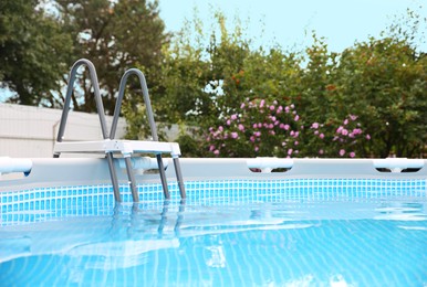 Photo of Above ground swimming pool with handrails and ladder in backyard