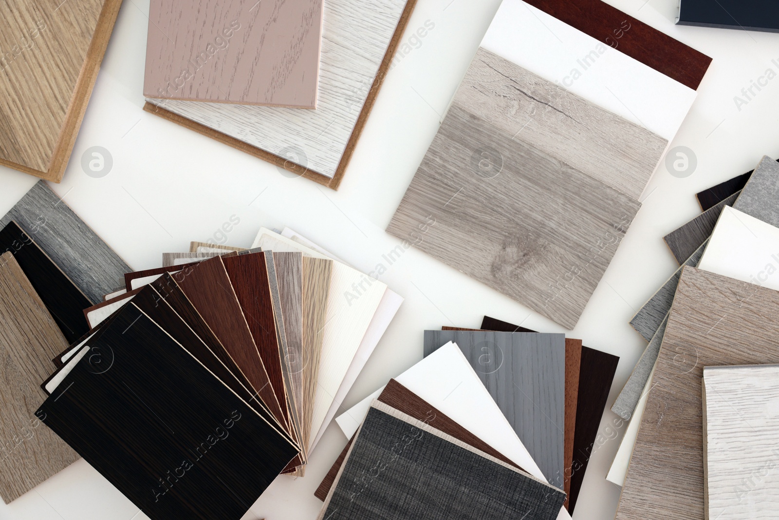 Photo of Different samples of wooden flooring on white table, top view