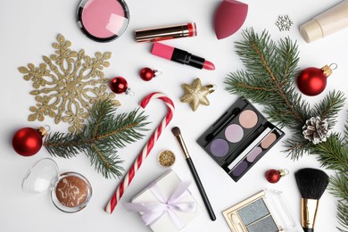 Photo of Different decorative cosmetic products and Christmas decor on white background, flat lay