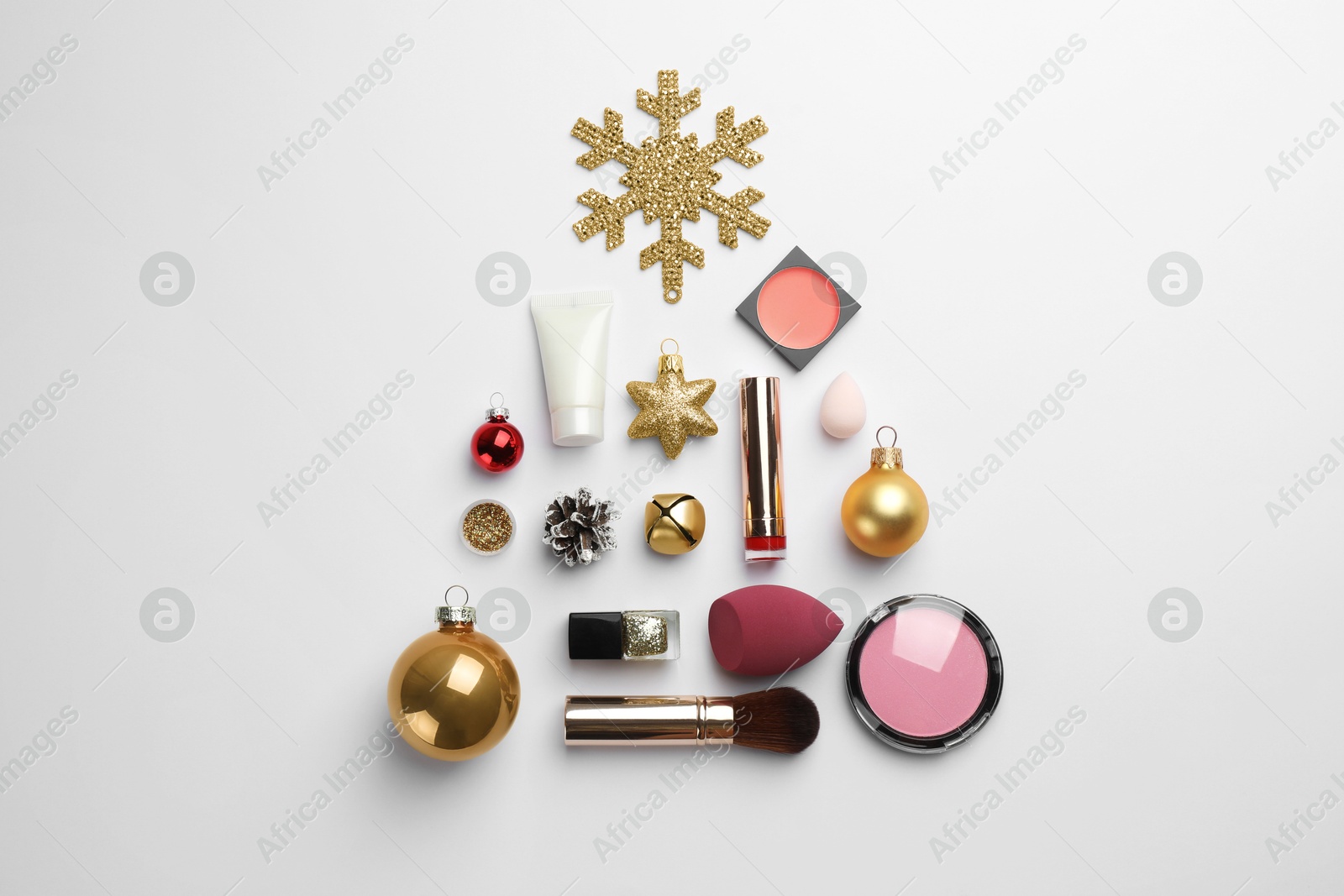 Photo of Christmas tree made of decorative cosmetic products and festive decor on white background, flat lay