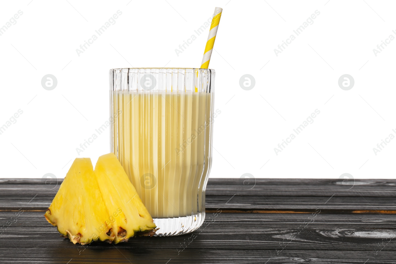 Photo of Tasty pineapple smoothie in glass and slices of fruit on wooden table against white background. Space for text