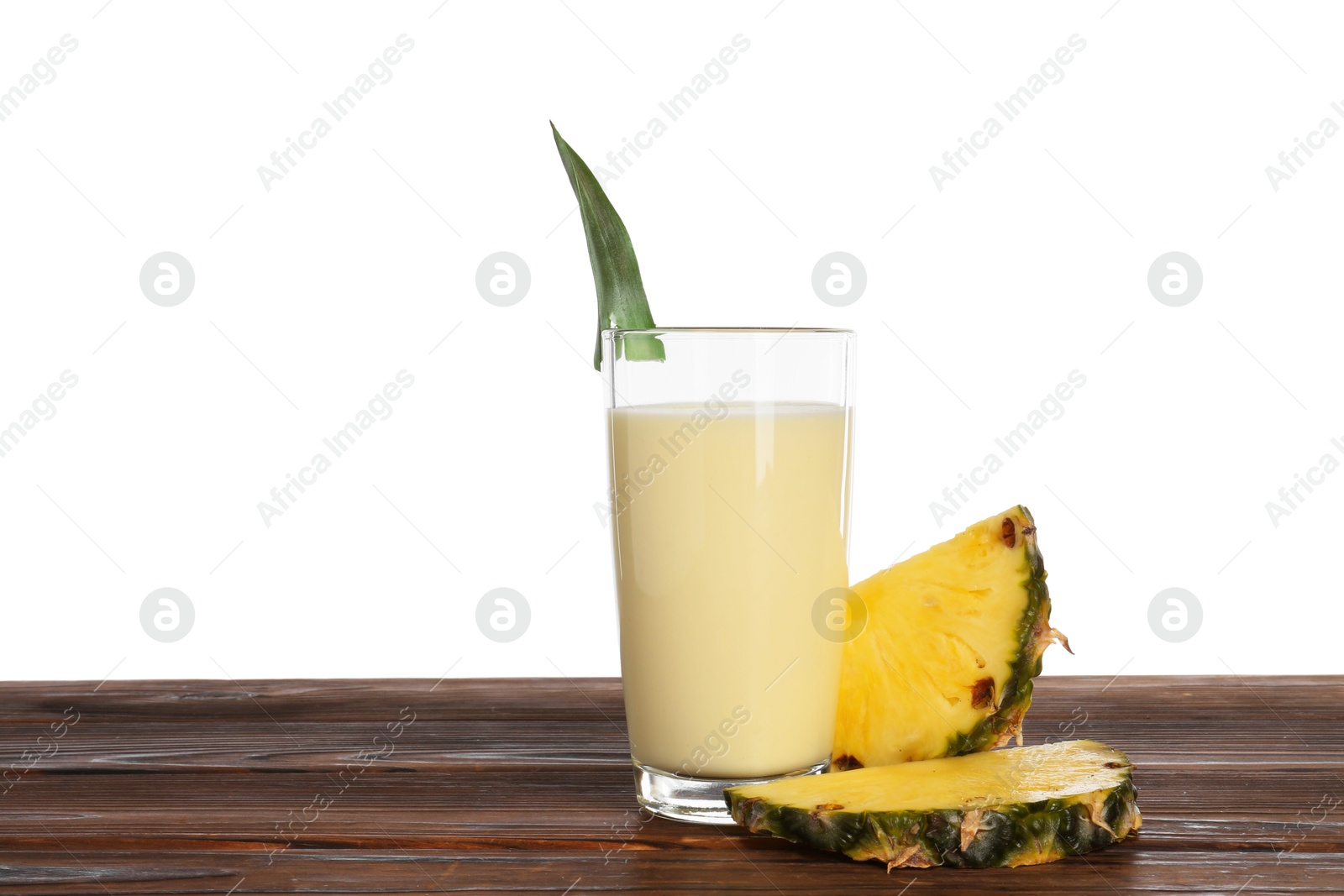 Photo of Tasty pineapple smoothie in glass and slices of fruit on wooden table against white background. Space for text