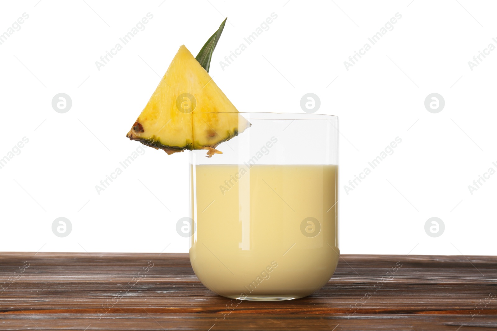 Photo of Tasty pineapple smoothie in glass and slice of fruit on wooden table against white background